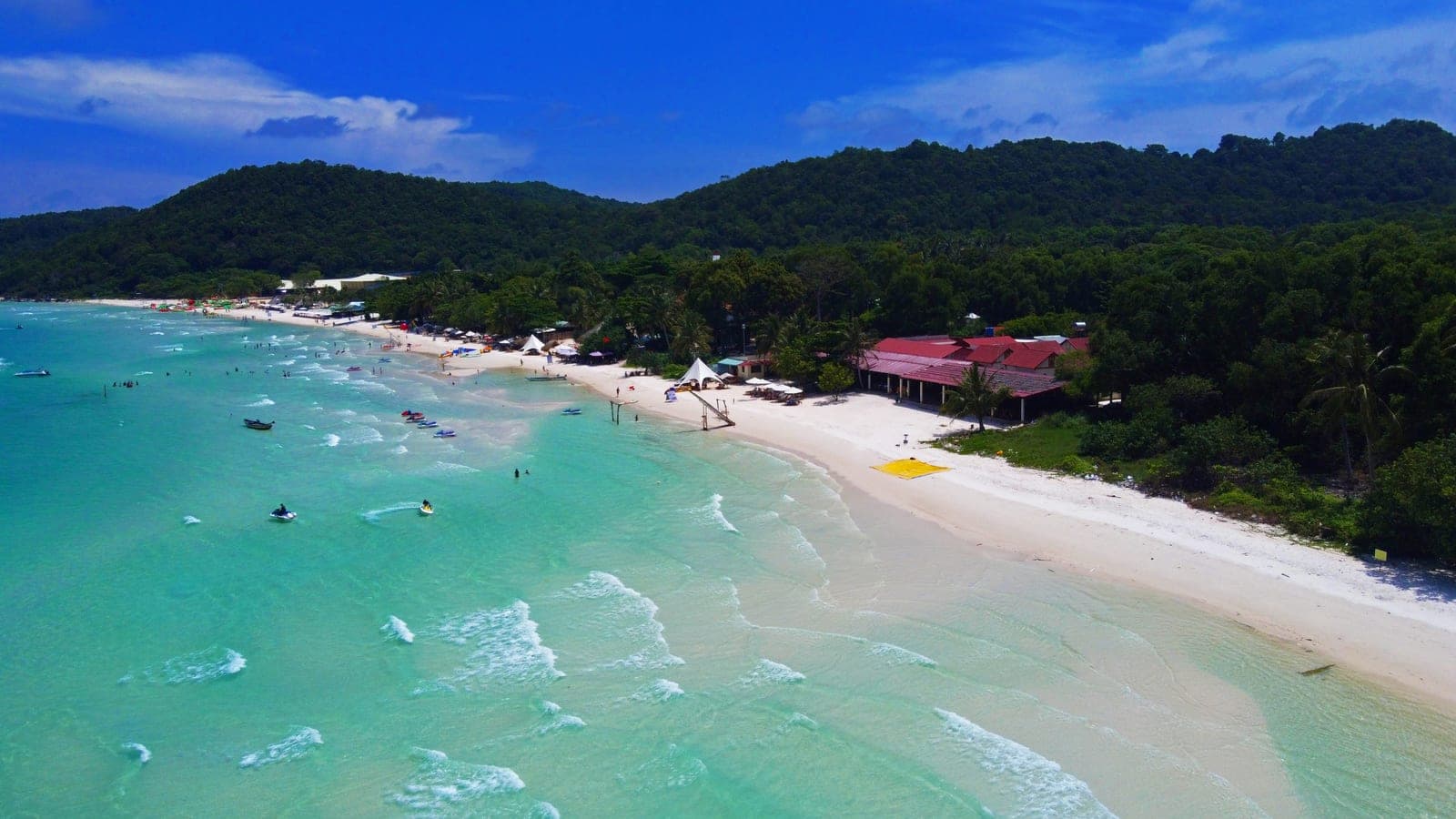 Pristine white sand and turquoise water at Bai Sao Beach, Phu Quoc Island, with tropical vegetation lining the shore