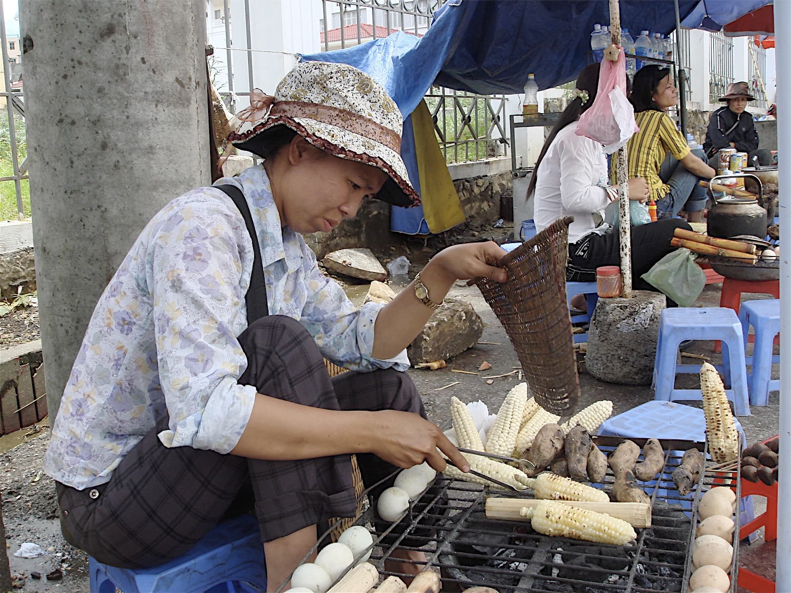 Street food vendor preparing food at a stall in Sapa, Vietnam, with cooking equipment and ingredients visible