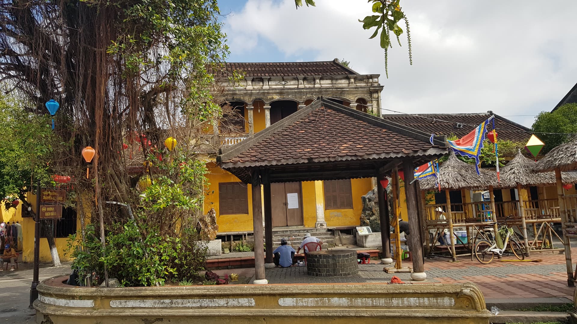 Historic Hoi An ancient town with traditional buildings, illuminated lanterns, and riverside architecture at sunset