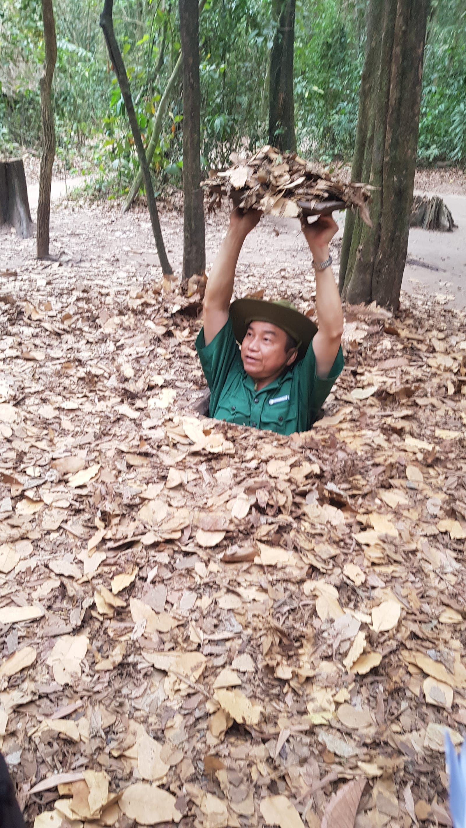 Entrance and sections of restored Viet Cong tunnels at Cu Chi with earthen walls, wooden supports, and wartime fortifications.