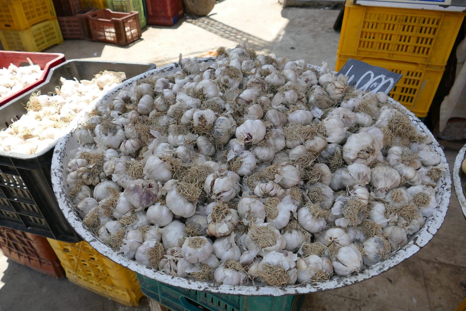 A bustling open-air street food market with vendor stalls, fresh ingredients on display, and local shoppers browsing traditional market foods