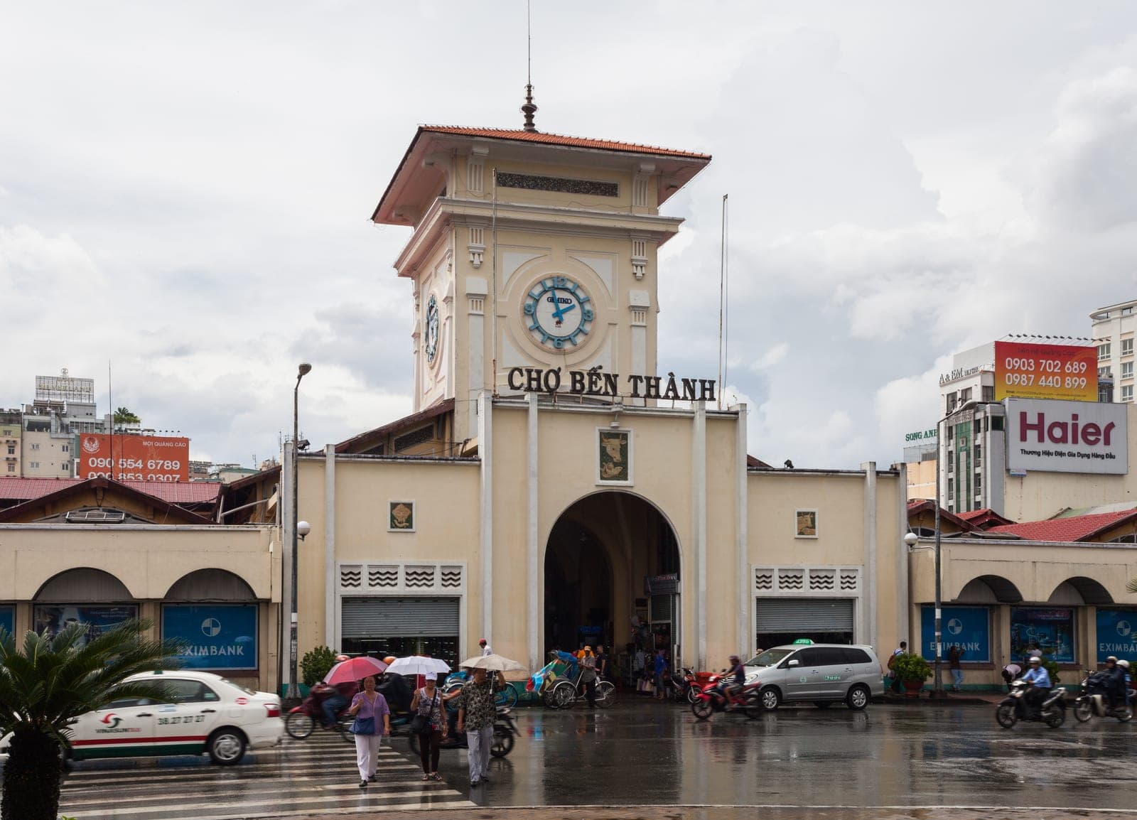 Ben Thanh Market entrance in Ho Chi Minh City with bustling Vietnamese vendors and shoppers in the busy central market district