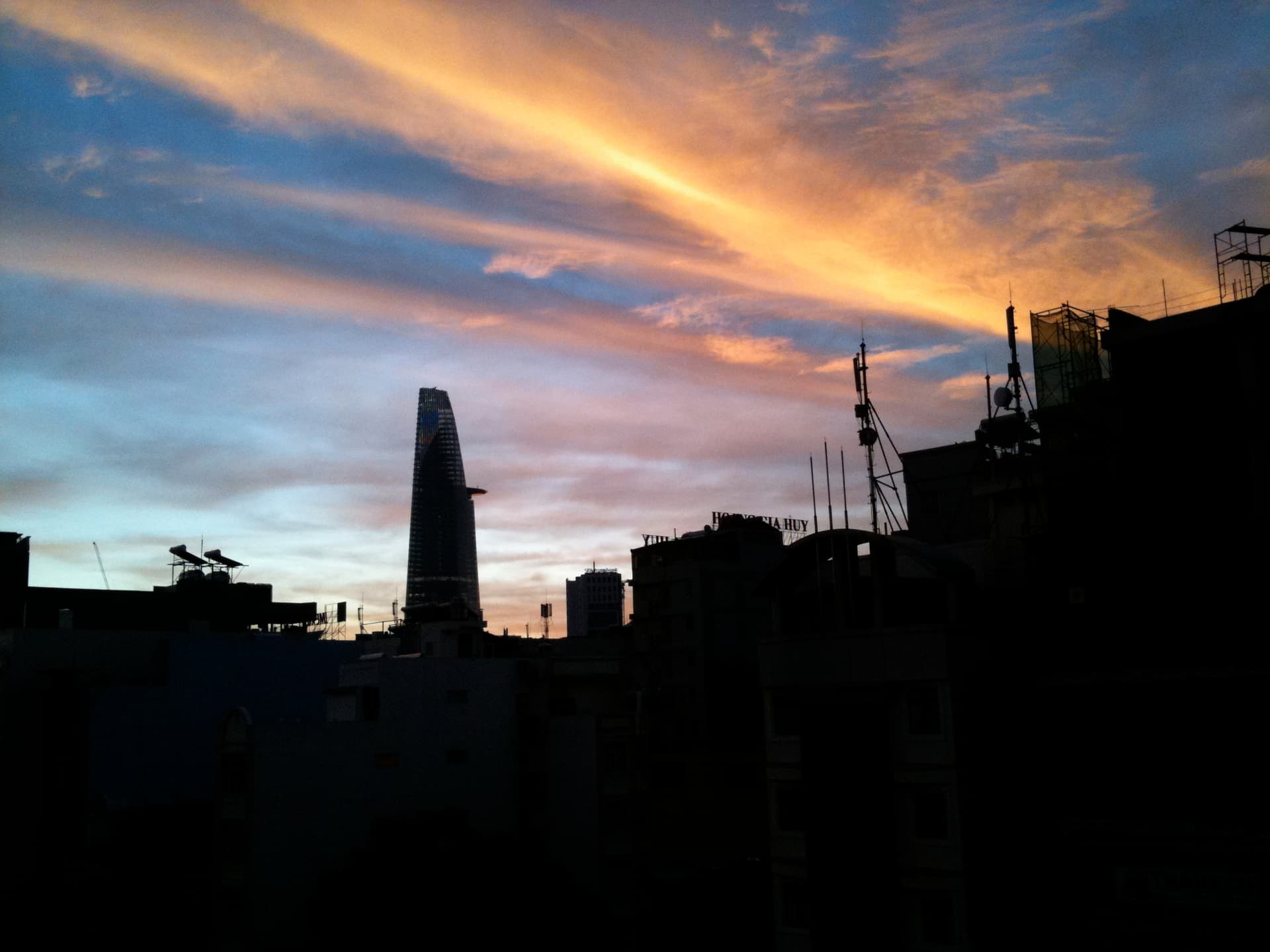 Ho Chi Minh City skyline illuminated by vibrant sunrise colors reflecting across urban landscape